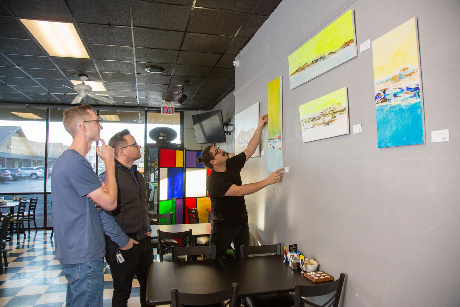 ARTISTIC IMPRESSION: Springfield Diner owner Omer Onder talks improvements at the restaurant with Longitude’s Dustin Myers and Jeremy Wells as he adjusts new artwork on display.
